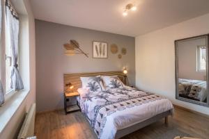 una camera da letto con un letto, un tavolo e uno specchio di Appartement Le Saver'Zaru, centre ville, T2 55m² a Saverne