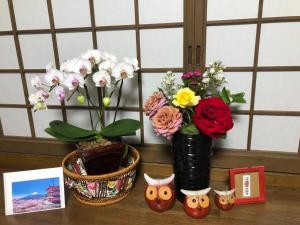 Una mesa con dos jarrones y flores. en Fukurou no Oyado - Vacation STAY 71243v, en Fuefuki