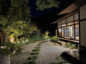 einen Garten in der Nacht mit Lichtern an der Seite eines Gebäudes in der Unterkunft Fukurou no Oyado - Vacation STAY 71243v in Fuefuki