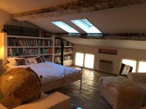 una camera con letto e una stanza con libreria di Ma Maison a Vence