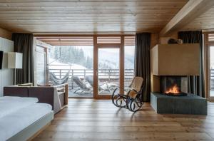 sypialnia z kominkiem, łóżkiem i kanapą w obiekcie Holzhotel Forsthofalm w mieście Leogang
