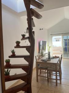 escalera de caracol de madera en una sala de estar con mesa en Casa Sol y Luna, en Costa Calma