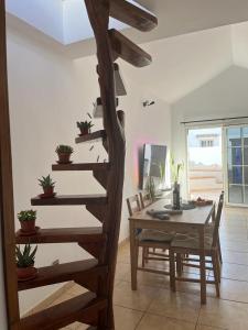 a wooden spiral staircase in a living room with a table at Casa Sol y Luna in Costa Calma