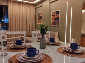 a dining room table with blue cups and plates on it at Rio Park Avenue Number 2 - By TRH Invest in Recife