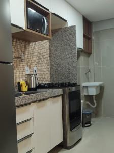 a kitchen with a microwave and a sink at Rio Park Avenue Number 2 - By TRH Invest in Recife