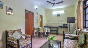 a living room with a table and chairs and a kitchen at Goa Garden Resort - Sandray Apartments & Villa at Benaulim - Colva beach in Colva