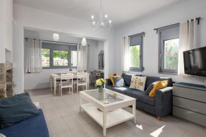 a living room with a couch and a tv at Dama Dama Villas in Gennadi