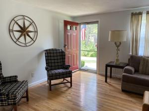 a living room with a couch and a chair at A Cozy Cape house steps to Restaurants & Beaches ~1.4 miles down scenic roads in Yarmouth
