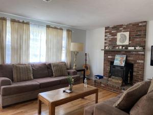 a living room with a couch and a fireplace at A Cozy Cape house steps to Restaurants & Beaches ~1.4 miles down scenic roads in Yarmouth