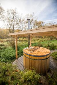 a wooden pergola and a wooden barrel with a hot tub at Luxury Glamping Room8 a private hideaway from Brussels in Huldenberg