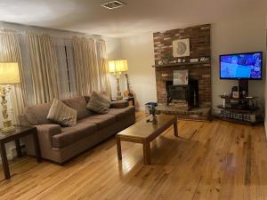 a living room with a couch and a fireplace at A Cozy Cape house steps to Restaurants & Beaches ~1.4 miles down scenic roads in Yarmouth