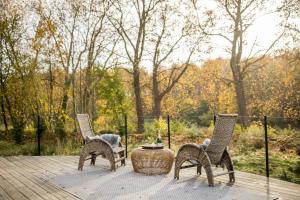 three chairs and a table on a wooden deck at Luxury Glamping Room8 a private hideaway from Brussels in Huldenberg