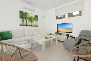 a living room with a couch and a tv at Villa Regina in Ayia Napa