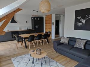 a living room with a couch and a table at Le grenier d Hermine in Gérardmer