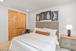 - une chambre avec un lit blanc et une porte en bois dans l'établissement 3br 3 1 2Ba Center of Everything New Listing On Our New Home, à Telluride