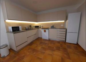 a large kitchen with white cabinets and appliances at Can Carles - Delta del Ebro in Poblenou del Delta