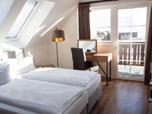 ein Hotelzimmer mit 2 Betten, einem Schreibtisch und einem Fenster in der Unterkunft StrandBerg's Onkel Tommys Hütte in Braunlage