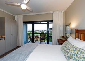 a bedroom with a bed and a sliding glass door at Le Mahi Guest House in Langebaan