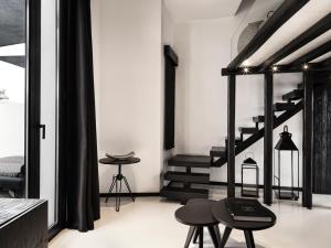 a living room with black stairs and stools at Liostasi in Ios Chora