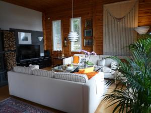 a living room with a white couch and a tv at Leena's B&B in Inkoo