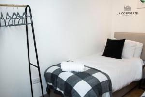 ein Schlafzimmer mit einem Bett mit einer schwarzen und weißen Decke in der Unterkunft 2 bed Apartment by UK Corporate Relocations Ltd in Warrington