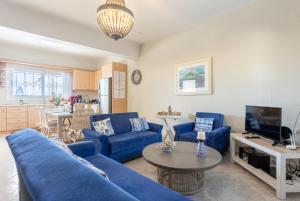 un soggiorno con divani blu e un tavolo di Villa Erasmia a Vlachata
