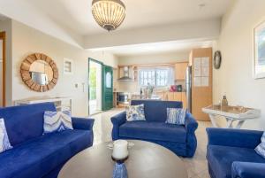 a living room with blue couches and a table at Villa Erasmia in Vlachata