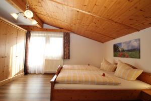 a bedroom with a large bed with a wooden ceiling at Obermooshof in Fügenberg