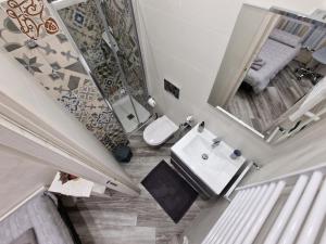 uma casa de banho com um lavatório, um WC e um espelho. em Appartamento in Piazza Vittorio Veneto con parcheggio, Torino em Turim