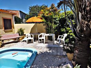 a patio with a table and chairs and an umbrella at Apart São Gabriel in São Gabriel