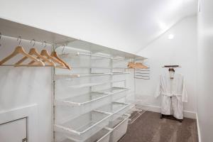 a walk in closet with white shelves and a mannequin at Rhone Retreat in Portland +34 photos