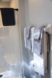 baño con toallas colgadas en un estante en The Dollar House, en Albert Lea