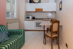 een kleine keuken met een tafel en een bank bij Town 6 - small studio in Cernobbio in Cernobbio