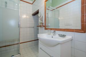 bagno bianco con lavandino e specchio di Town 6 - small studio in Cernobbio a Cernobbio