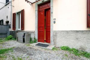 een rode deur aan de zijkant van een gebouw bij Town 6 - small studio in Cernobbio in Cernobbio