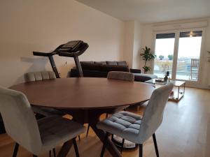 a living room with a wooden table and chairs at Parc EXPO prte d'orléans ORLY CDG Terrasse parking in Bagneux +23 photos