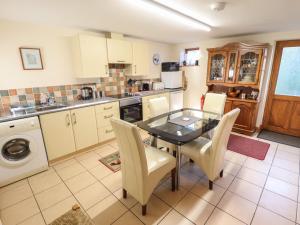 a kitchen with a dining room table and chairs at Clare's Cottage in Grainthorpe