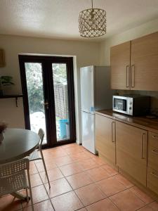 a kitchen with a table and a white refrigerator at lovely 4 bedroom 2 bathroom home in London