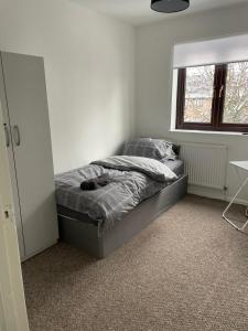 a bedroom with a bed and a window at lovely 4 bedroom 2 bathroom home in London