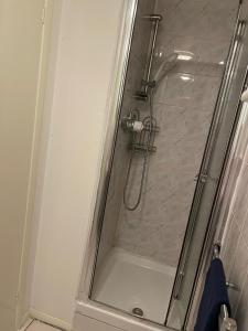 a shower in a bathroom with a glass door at lovely 4 bedroom 2 bathroom home in London