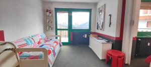 a small room with a bed and a desk in it at Hostdomus - Modern Art Flat in Sestriere