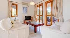 uma sala de estar com dois sofás brancos e uma mesa de centro em 2 bedroom Villa Oleander with private pool and garden, Aphrodite Hills Resort em Kouklia