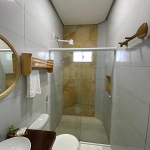 uma casa de banho com um chuveiro, um WC e um lavatório. em Pousada Delta Village em Tutóia