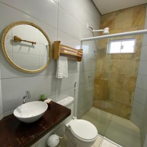 ein Bad mit einem WC, einem Waschbecken und einer Dusche in der Unterkunft Pousada Delta Village in Tutóia
