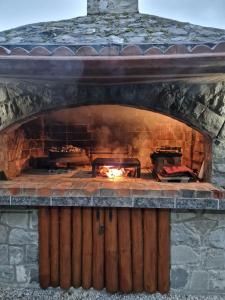 a large stone fireplace with a fire in it at Apartmani Kubo in Kakanj