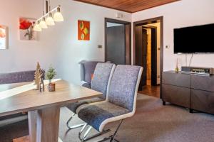 a living room with a table and chairs and a television at Sirena Carezza Apartment Karersee in Carezza al Lago