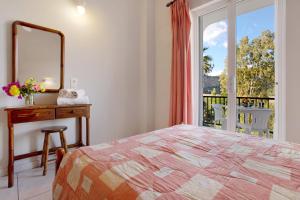 a bedroom with a bed and a mirror and a balcony at Dolphin Studio 3 in Keri