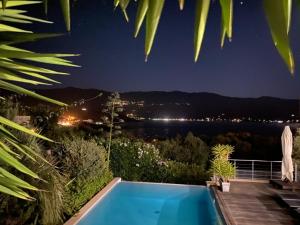 a swimming pool at night with a view of the water at Casaluce in Casaglione