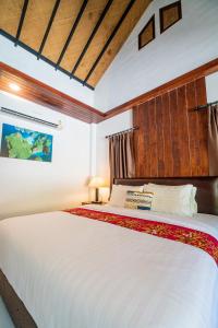 a bedroom with a large white bed in a room at Chunut House Resort in Phi Phi Islands