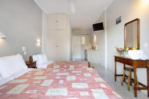 a bedroom with a bed and a desk and a mirror at Dolphin Studio Sea View 10 in Keri